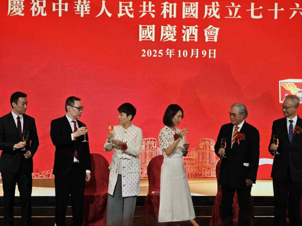 主礼嘉宾与管理层于国庆酒会台上举杯合影（红色主视觉背景）