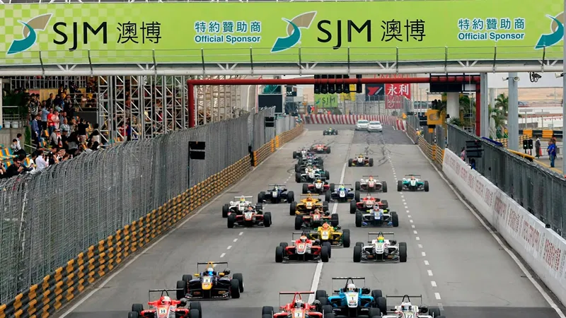 澳门格兰披治大赛车发车画面，赛道上方悬挂SJM澳博赞助横幅