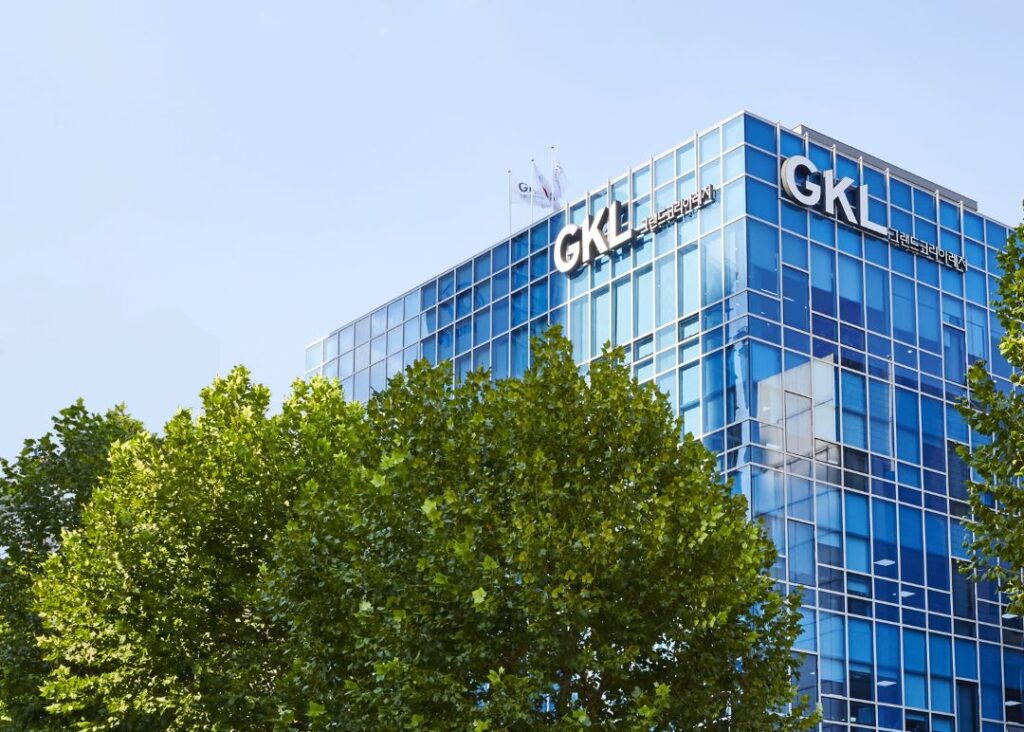 Grand Korea Leisure 首尔总部外观 蓝色玻璃幕墙办公楼 与前景绿树