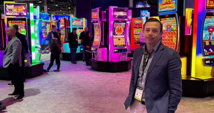 Aristocrat 展台前的产品经理与多款霓虹老虎机机台合影，展示 Dragon Link 系列人气