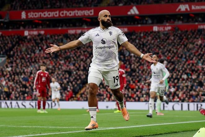 曼联球员在安菲尔德进球后张开双臂庆祝，背景是利物浦主场观众席，象征红魔打破9年不胜魔咒。