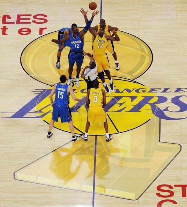 NBA总决赛开场跳球画面，地板中央绘有大型奥布莱恩冠军奖杯与总决赛标识