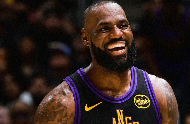 NBA 洛杉磯湖人隊球星勒布朗·詹姆斯（LeBron James）身穿紫色球衣，在比賽中面帶微笑、大聲歡呼或大笑的特寫鏡頭。此圖展示了這位籃球巨星在場上的自信與激情。