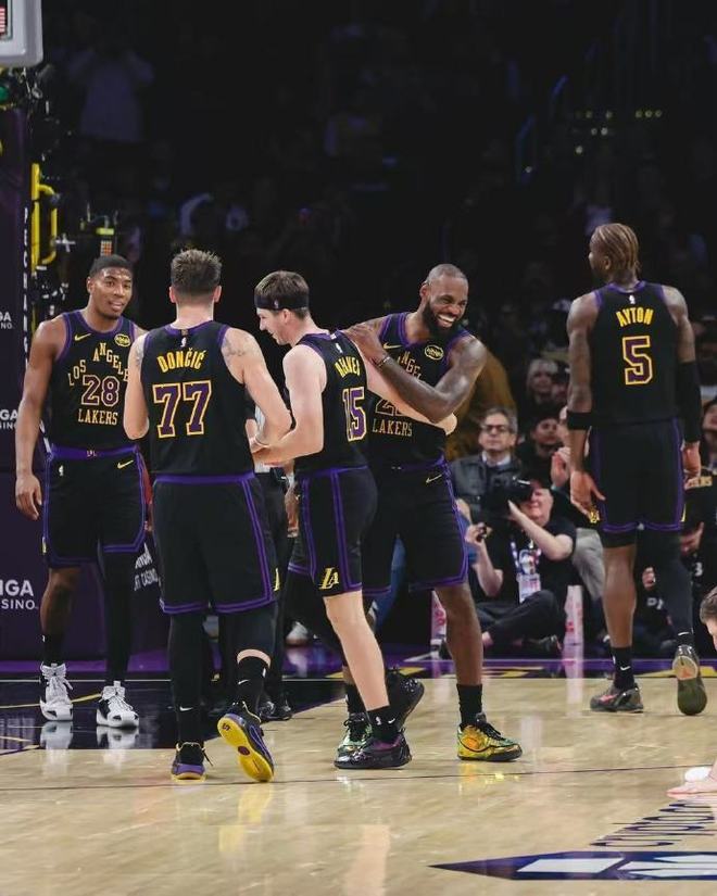 洛杉磯湖人隊球員在籃球場上圍成一圈,勒布朗·詹姆斯在其中與隊友慶祝或互相鼓勵。