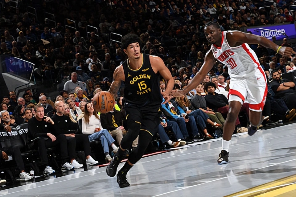 金州勇士队(黑色球衣,15号)球员在主场比赛中带球快速推进,休斯顿火箭队球员(红白球衣,30号)紧追防守。此图反映了勇士队在输给火箭后,主帅科尔所说的球队有更大潜力,需要继续努力才能提升稳定性。