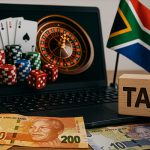一张描绘南非兰特（Rand）纸币或硬币堆，背景是网络博彩网站界面或电子老虎机的图像。此图象征南非政府提议对网络赌博总收入征收 20% 全国性税收，以增加财政收入和解决赌博成瘾问题。