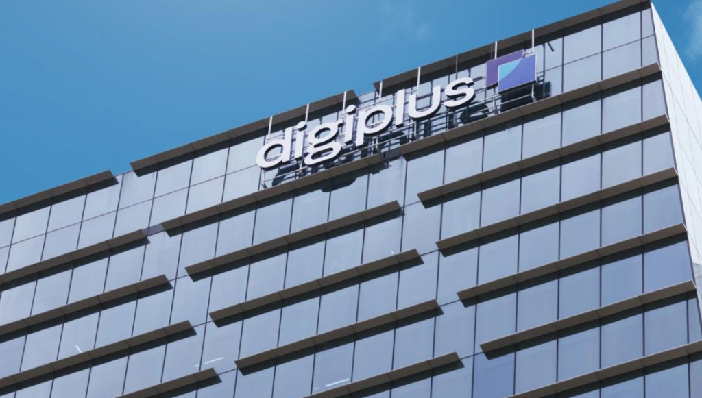 DigiPlus 公司的现代化玻璃幕墙办公大楼特写，巨大的 digiplus 标志清晰可见。这座建筑象征着菲律宾领先的数字娱乐和电竞游戏供应商 DigiPlus 的企业形象，以及其进行线上线下平台整合和马尼拉 New Coast 酒店战略收购的科技创新重点。