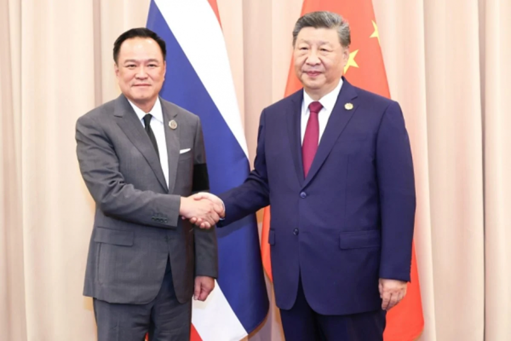 双边会晤现场，两国官员在国旗前握手合影，体现合作与友好交流主题。