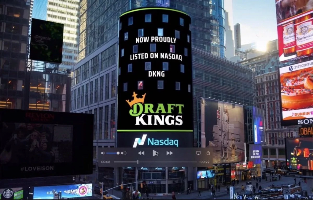 纳斯达克大屏上的DraftKings标志与上市信息，反映公司股市与业绩指引动态