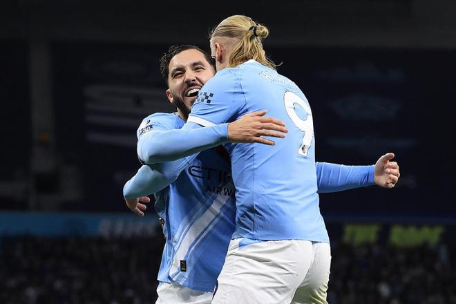 哈兰德与队友拥抱庆祝，曼城扩大优势，主场气氛火热。