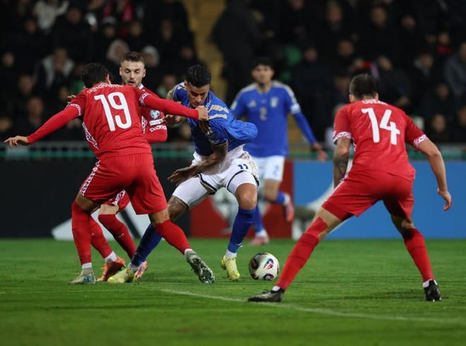 意大利前锋在禁区内背身控球，周围三名摩尔多瓦球员合围拦截的瞬间