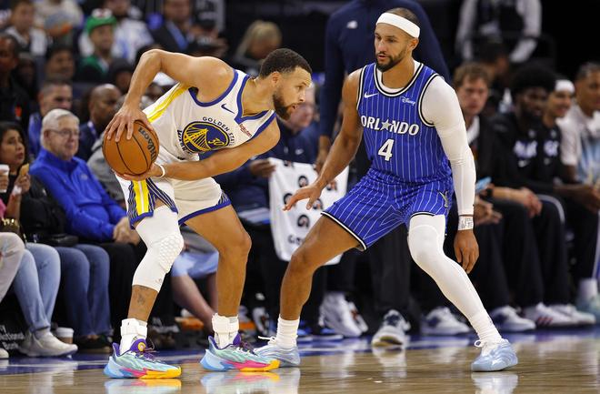 勇士球星库里在对阵魔术比赛中持球单打,对方后卫紧逼防守的比赛画面