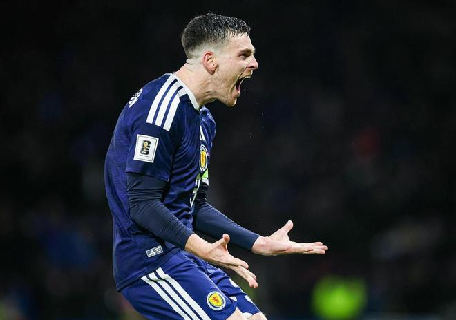 苏格兰队核心球员进球后激情怒吼，双手张开宣泄情绪的特写镜头