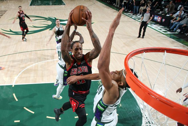 NBA比赛中球员在篮下强势上篮的现场瞬间。