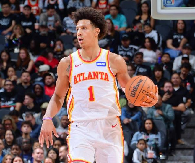 亚特兰大老鹰球员运球过半场组织进攻,场边观众聚精会神观看