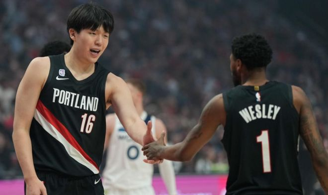 杨瀚森与队友击掌庆祝比赛得分的镜头