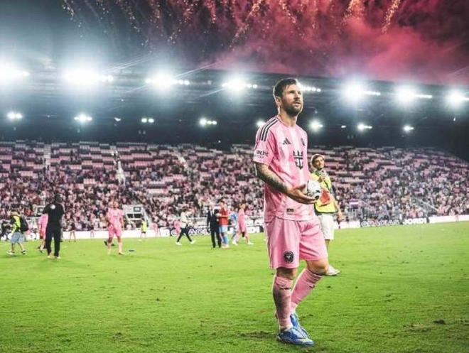 梅西在主场草坪上手捧比赛用球，身后看台与烟花映衬，迈阿密国际4-0晋级东部半决赛。