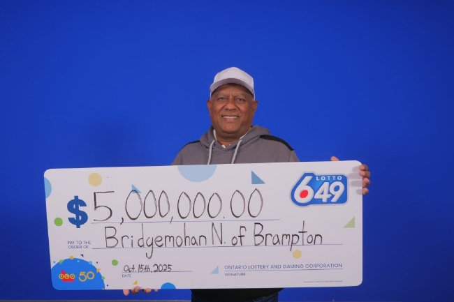 加拿大彩票頭獎得主尼巴爾（汽修工人）在領獎中心，手持一張象徵 500 萬加元巨額獎金的支票，展示他準備用獎金進行投資創業並創造就業機會的喜悅。