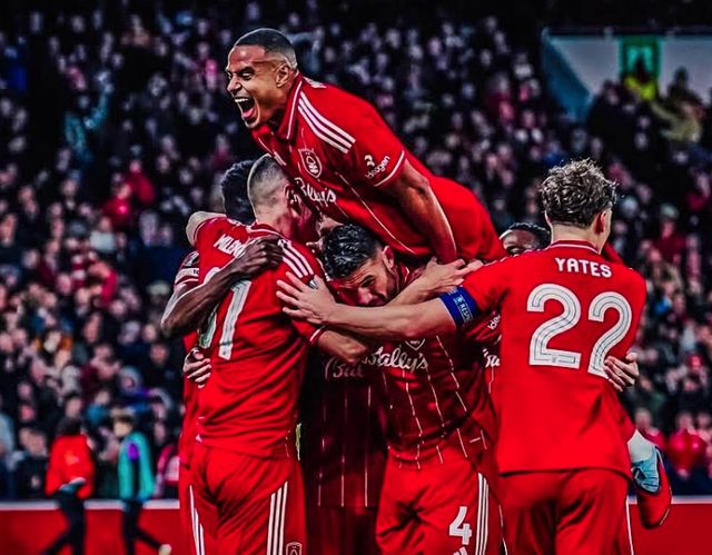 诺丁汉森林队（红色球衣）球员在欧联比赛中兴奋地叠罗汉庆祝进球，体现了主帅肖恩·戴奇带来的团队凝聚力和高涨士气。此图象征球队在戴奇执教下取得 3-0 大胜马尔默等胜利后的双线狂飙和稳定性。