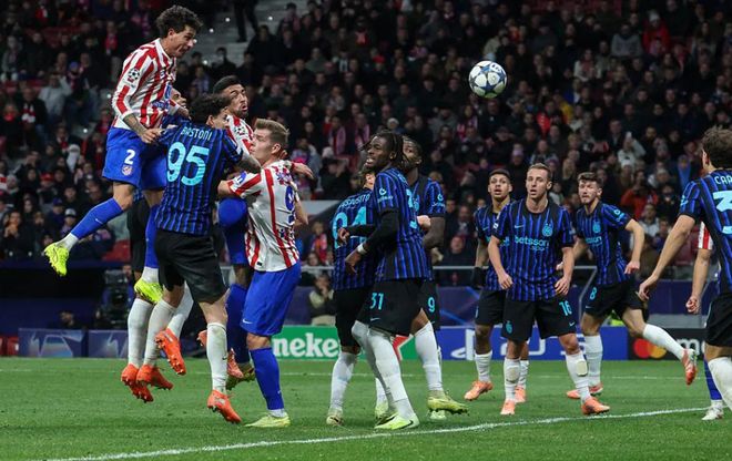 国际米兰和马德里竞技球员在欧冠赛场上跳起争抢头球（高空球），此场景发生在国米客场 1-2 遭绝杀的关键比赛中。此图反映了欧冠赛场上为争夺积分和晋级形势的激烈竞争。