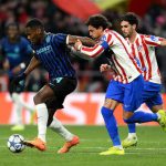 国际米兰（黑蓝条纹球衣）球员在欧冠联赛客场比赛中带球突破，受到马德里竞技（红白条纹球衣）球员的紧密防守。此图象征国米在欧冠第 5 轮中被马竞绝杀，遭遇赛季首败的激烈对抗瞬间。