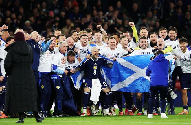 苏格兰全队围在一起高举国旗庆祝晋级世界杯的集体合影