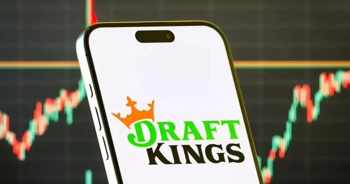 智能手机屏幕显示DraftKings预测市场（DraftKings Predictions）应用程序的标志，背景是金融市场上涨的K线图。