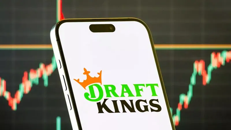 智能手机屏幕显示DraftKings预测市场（DraftKings Predictions）应用程序的标志，背景是金融市场上涨的K线图。