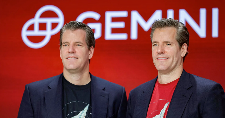 Gemini 交易所创始人泰勒·温克莱沃斯和卡梅隆·温克莱沃斯站在红色的公司 Logo（Gemini）前，身穿西装和印有图案的T恤。