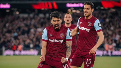 西汉姆联队球员(背号10和15)在比赛中庆祝进球,表情激动,身穿深红色主场球衣。