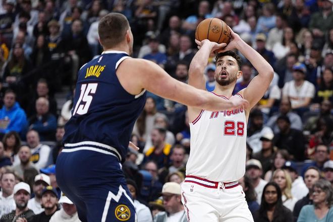 休斯顿火箭队球员申京(Alperen Şengün,28号)身穿白色球衣在比赛中跳投出手,面前是掘金队核心约基奇(Nikola Jokić,15号)的防守。