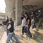 澳门司法警察（司警）逮捕涉嫌非法货币兑换的嫌疑人，嫌疑人被带离建筑物，体现了警方对“赌博用钱”活动的执法行动。