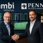 Kambi 与 PENN Entertainment 高层代表在体育博彩运营中心握手庆祝合作延期的现场照片。