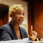 马萨诸塞州总检察长安德里亚·乔伊·坎贝尔在听证会上发言，手指指向前方，讨论对Kalshi的禁令。