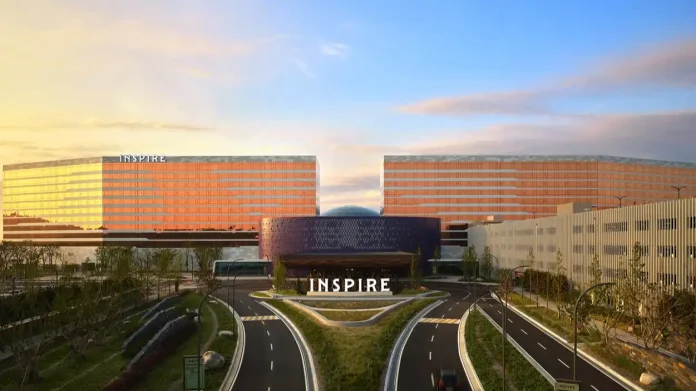 韩国仁川 Mohegan INSPIRE 综合度假村宏伟的外观全景，两座酒店大楼在日落余晖中闪耀，中央是独特的圆形入口建筑。