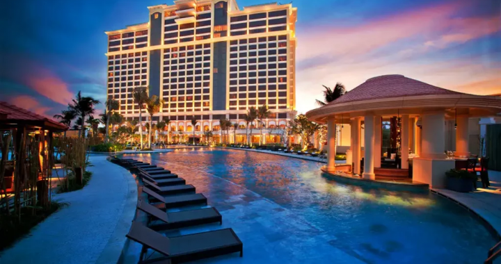 越南Grand Ho Tram赌场度假村的豪华夜景，显示室外游泳池和灯火辉煌的酒店大楼。