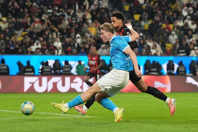 霍伊伦在比赛中突破AC米兰防守球员完成射门瞬间。