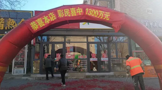 辽宁营口中出体彩超级大乐透1300万巨奖的实体店：门前挂着巨大的红色拱门和条幅，庆祝彩民中得1300万元大奖。