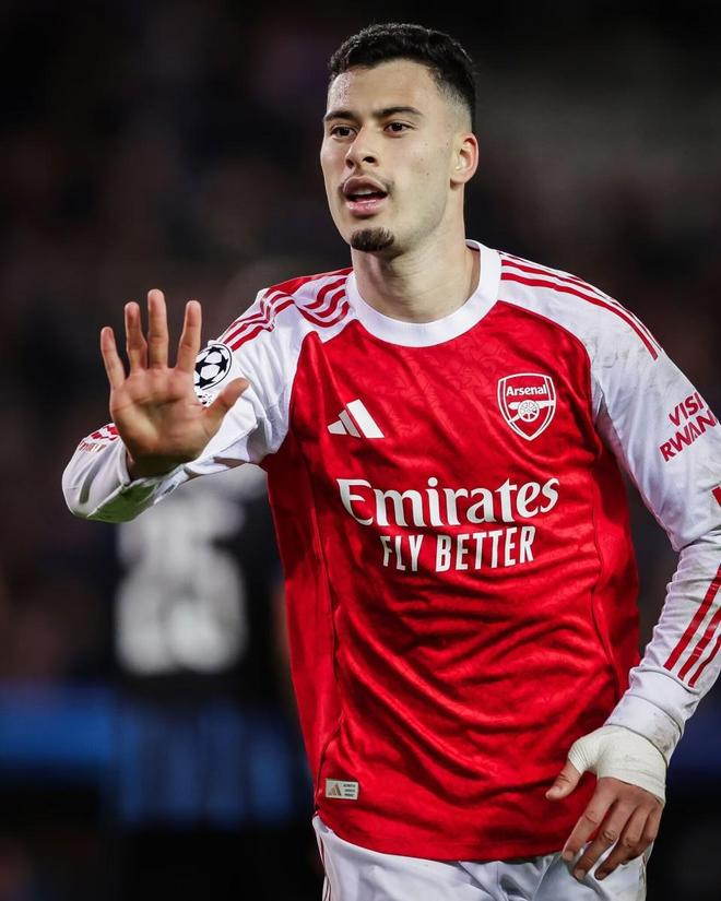 阿森納球星馬丁內利(Gabriel Martinelli)穿著紅白球衣的特寫鏡頭,表情專注,高舉五指,反映比賽中的狀態。