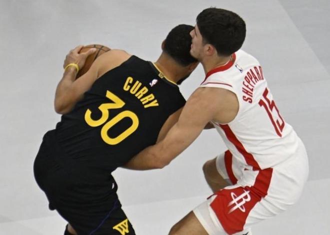 金州勇士隊球星斯蒂芬·庫里(Stephen Curry)背對鏡頭,與休斯頓火箭隊的謝潑德(Shepherd)在NBA比賽中進行身體對抗。