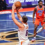 太陽隊球員格雷森·阿倫（Grayson Allen，身穿8號球衣）在比賽中跳投出手，雷霆隊球員在旁防守。