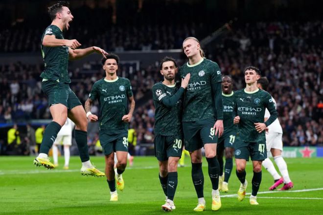 皇家馬德里球員（白衣）在足球比賽中做出鏟球防守，與另一名深色球衣球員進行激烈對抗。