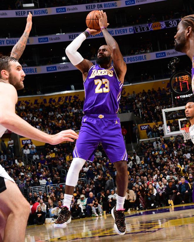 馬刺隊球員（5號）持球，面對湖人隊球員（紫色球衣）的嚴密防守和卡位，展現 NBA 比賽的內線對抗。