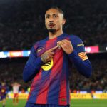 巴塞羅那球員拉菲尼亞（Raphinha）進球後，指著巴薩隊徽，身穿主場球衣。