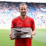 凯恩身穿拜仁球衣手捧奖杯在球场合影