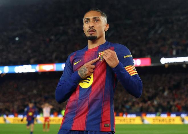 巴塞羅那球員拉菲尼亞（Raphinha）進球後，指著巴薩隊徽，身穿主場球衣。