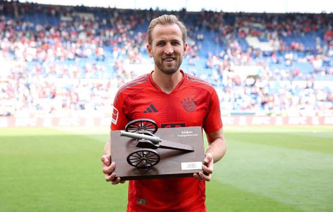 凯恩身穿拜仁球衣手捧奖杯在球场合影