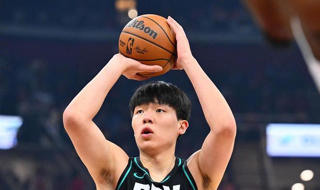 中国球员杨瀚森在NBA比赛中手持威尔逊篮球，准备进行罚球或投篮的近距离特写。