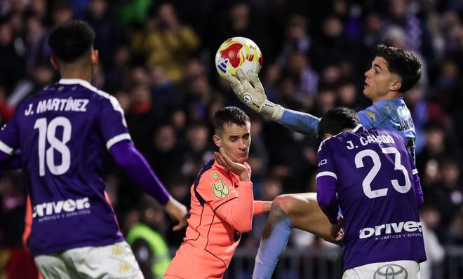 巴塞罗那球员（身穿橙色球衣，中间）在国王杯比赛中尝试头球攻门，与对方防守球员和守门员（正在扑球）激烈争顶。