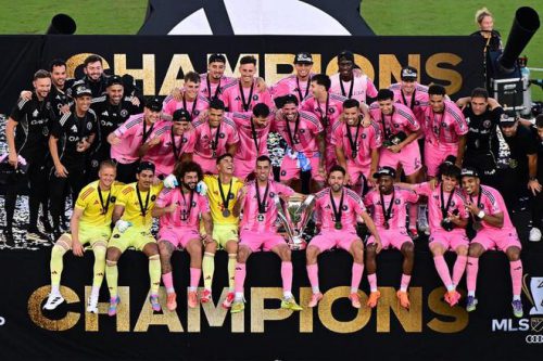 迈阿密国际全队球员身穿粉色球衣,手捧奖杯,庆祝赢得队史首座美职联总冠军。